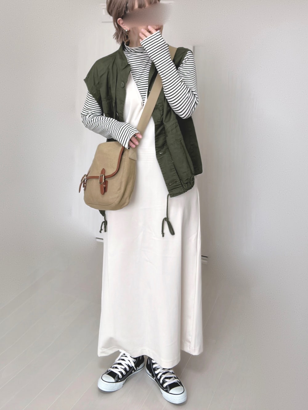 ホワイト系のワンピース、ホワイト系のTシャツ/カットソー、グリーン系のその他アウターを着用したレディースの冬コーディネートの4枚目の写真