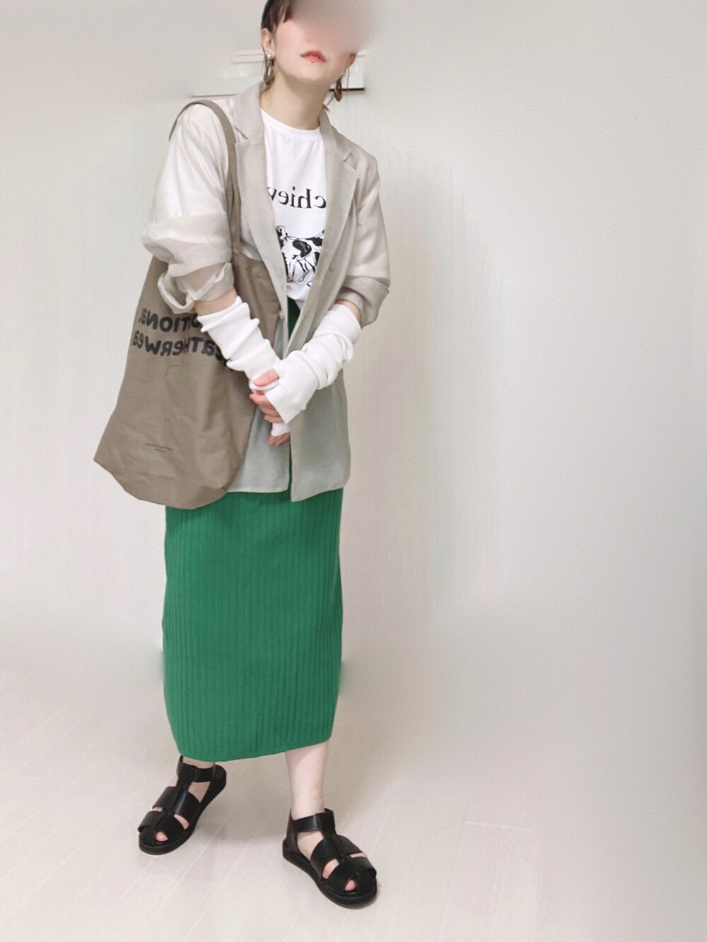 グレー系のテーラードジャケット、ブラウン系のトートバッグ、グリーン系のスカートを着用したレディースの夏コーディネートの3枚目の写真
