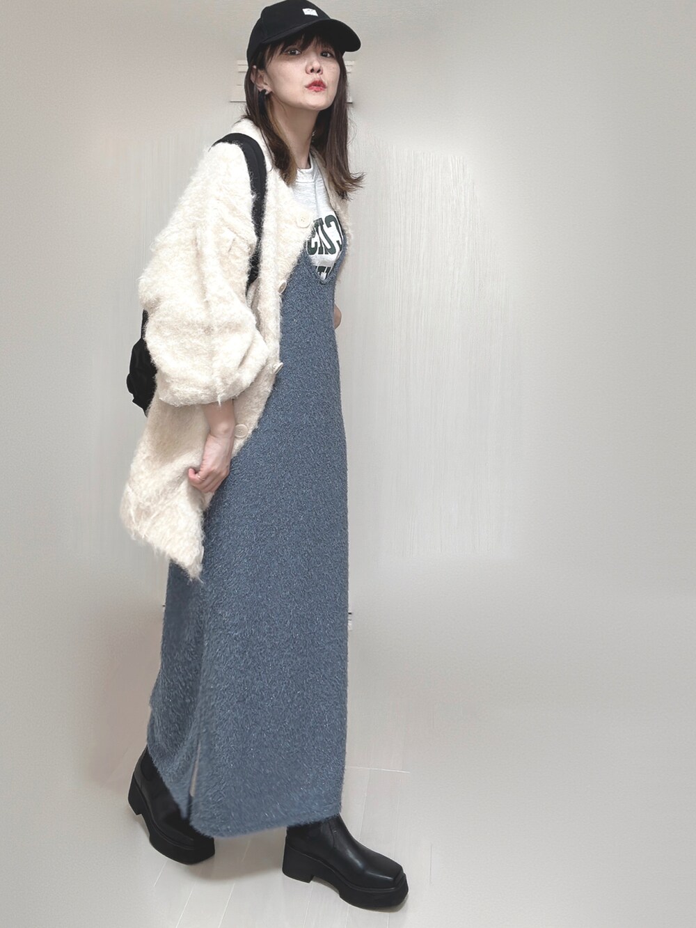 ベージュ系のカーディガン/ボレロ、ブラック系のブーツ、ブラック系のバックパック/リュックを着用したレディースの秋コーディネートの3枚目の写真