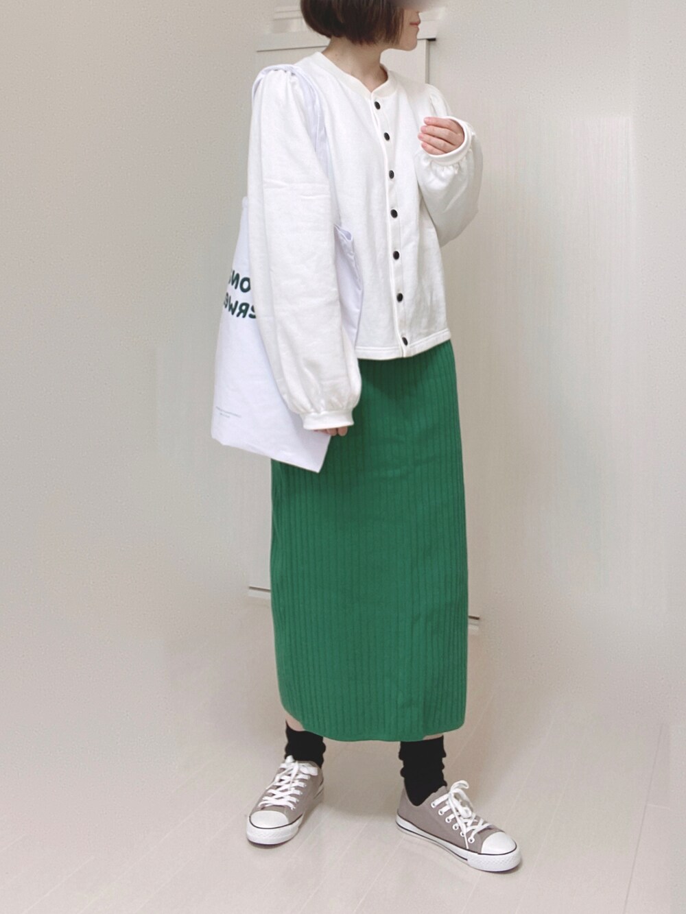 ブラック系のカーディガン/ボレロ、ホワイト系のトートバッグ、グリーン系のスカートを着用したレディースの春コーディネートの4枚目の写真