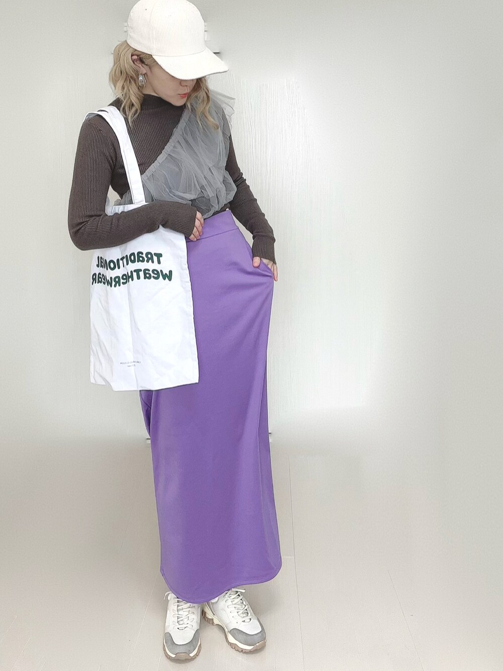 ホワイト系のトートバッグ、パープル系のスカート、ベージュ系のスニーカーを着用したレディースの春コーディネートの2枚目の写真
