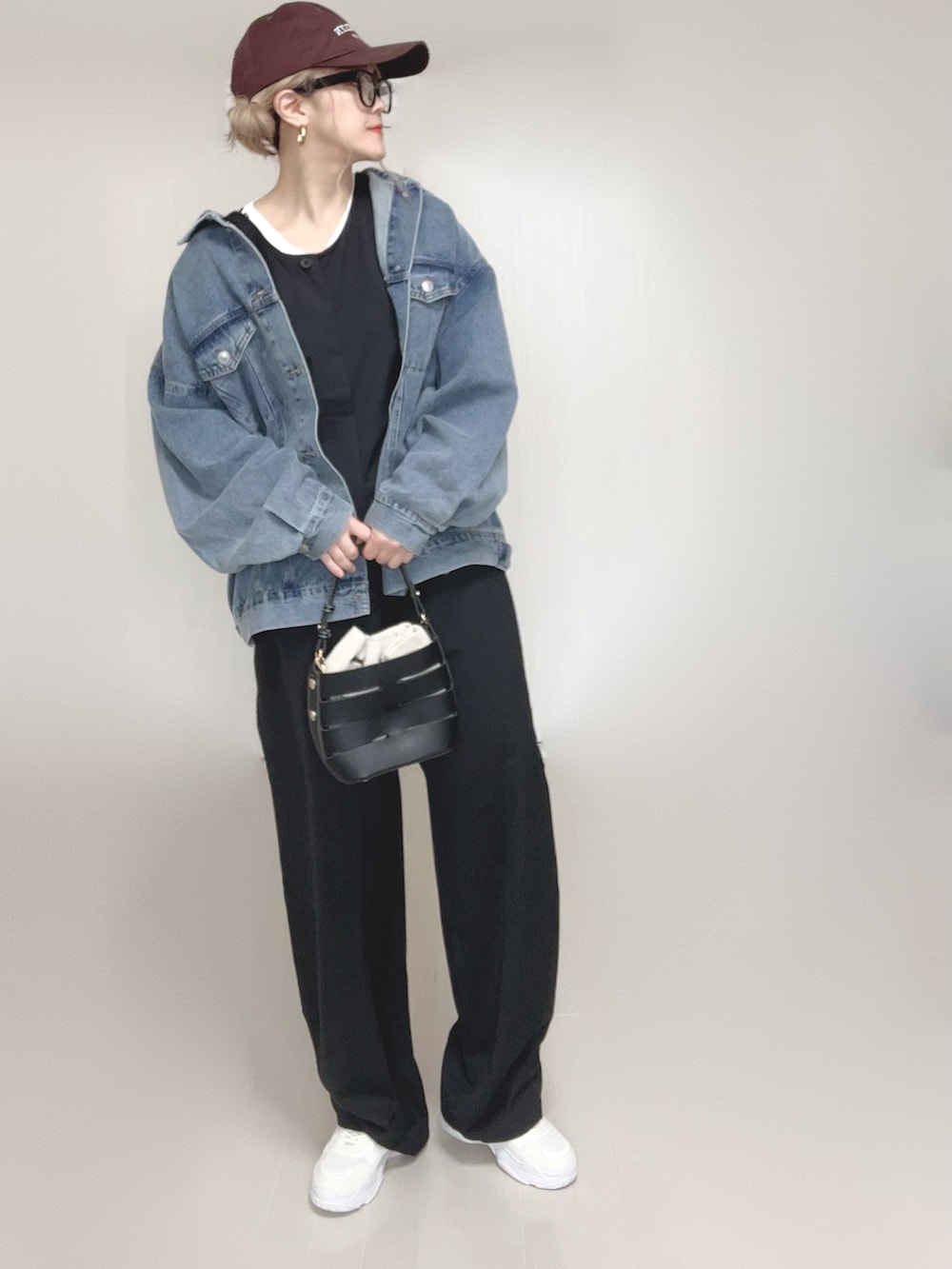 ブルー系のデニムジャケット、ブラック系のつなぎ/オールインワン、ホワイト系のTシャツ/カットソーを着用したレディースの春コーディネートの2枚目の写真