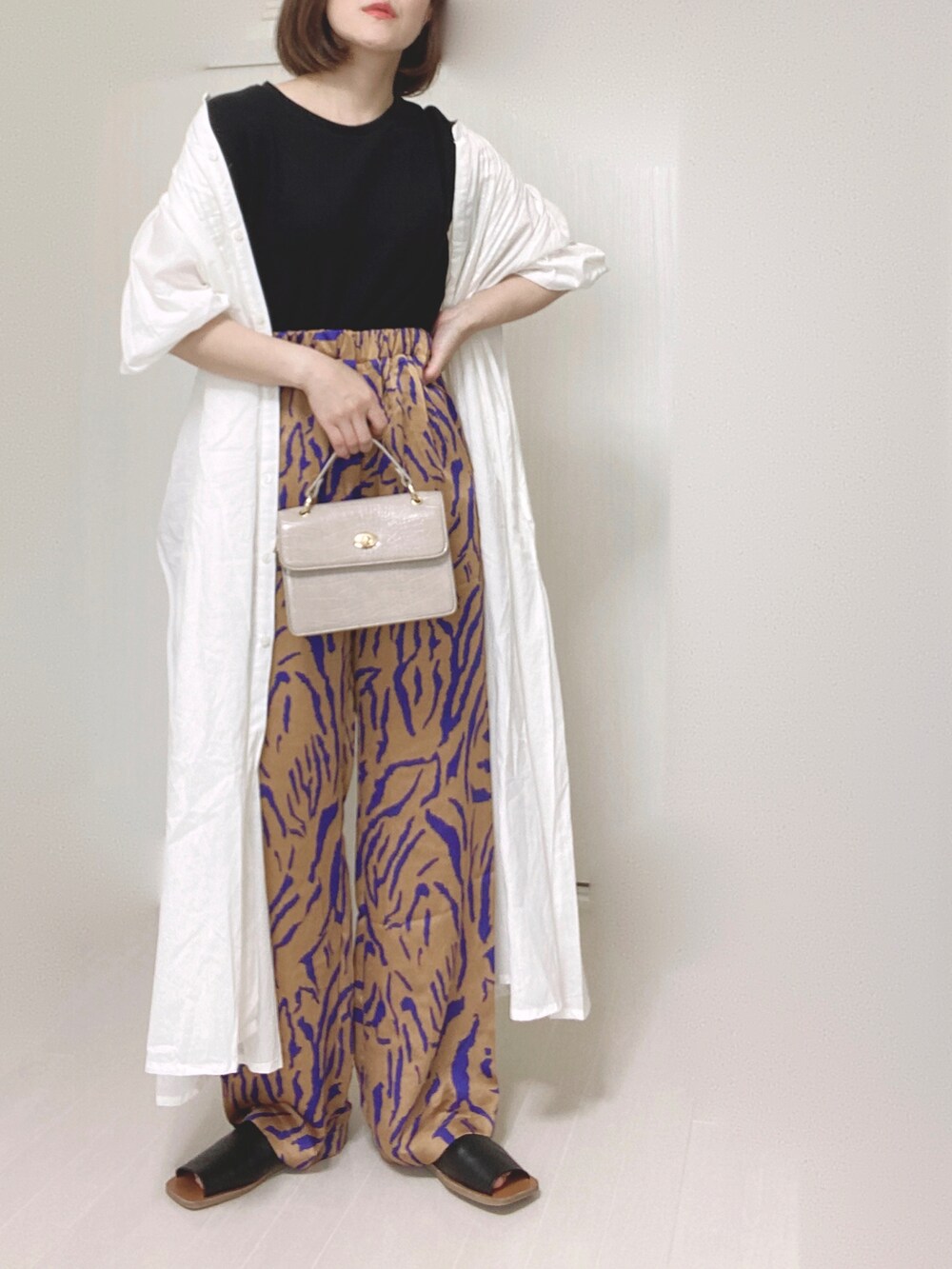 ホワイト系のシャツワンピース、オレンジ系のその他パンツ、ベージュ系のショルダーバッグを着用したレディースの夏コーディネートの4枚目の写真