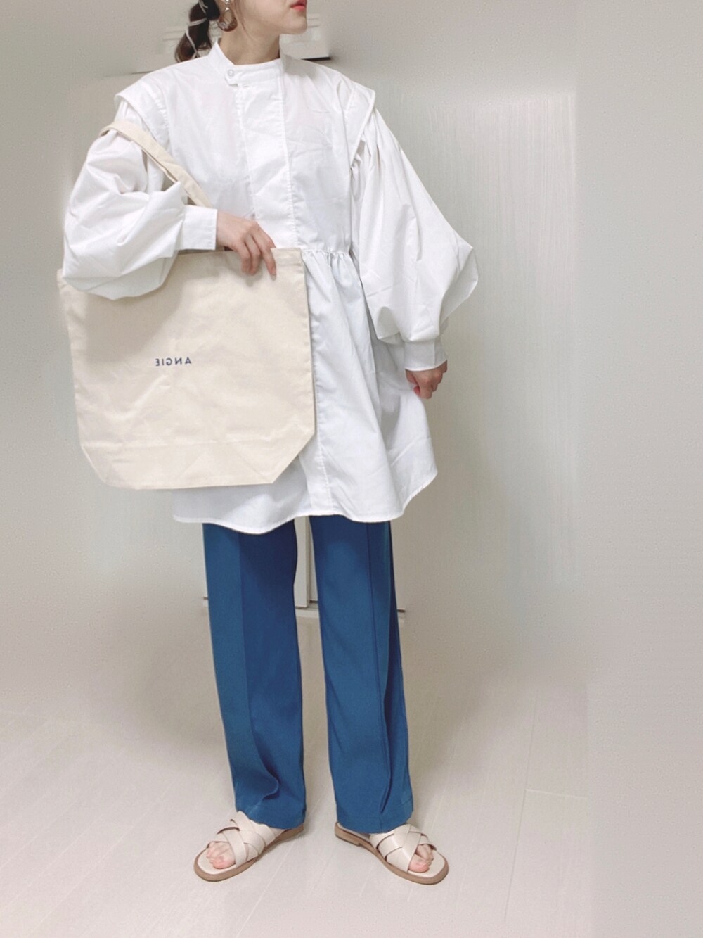 ブルー系のその他パンツ、ホワイト系のトートバッグ、ホワイト系のチュニックを着用したレディースの春コーディネートの2枚目の写真