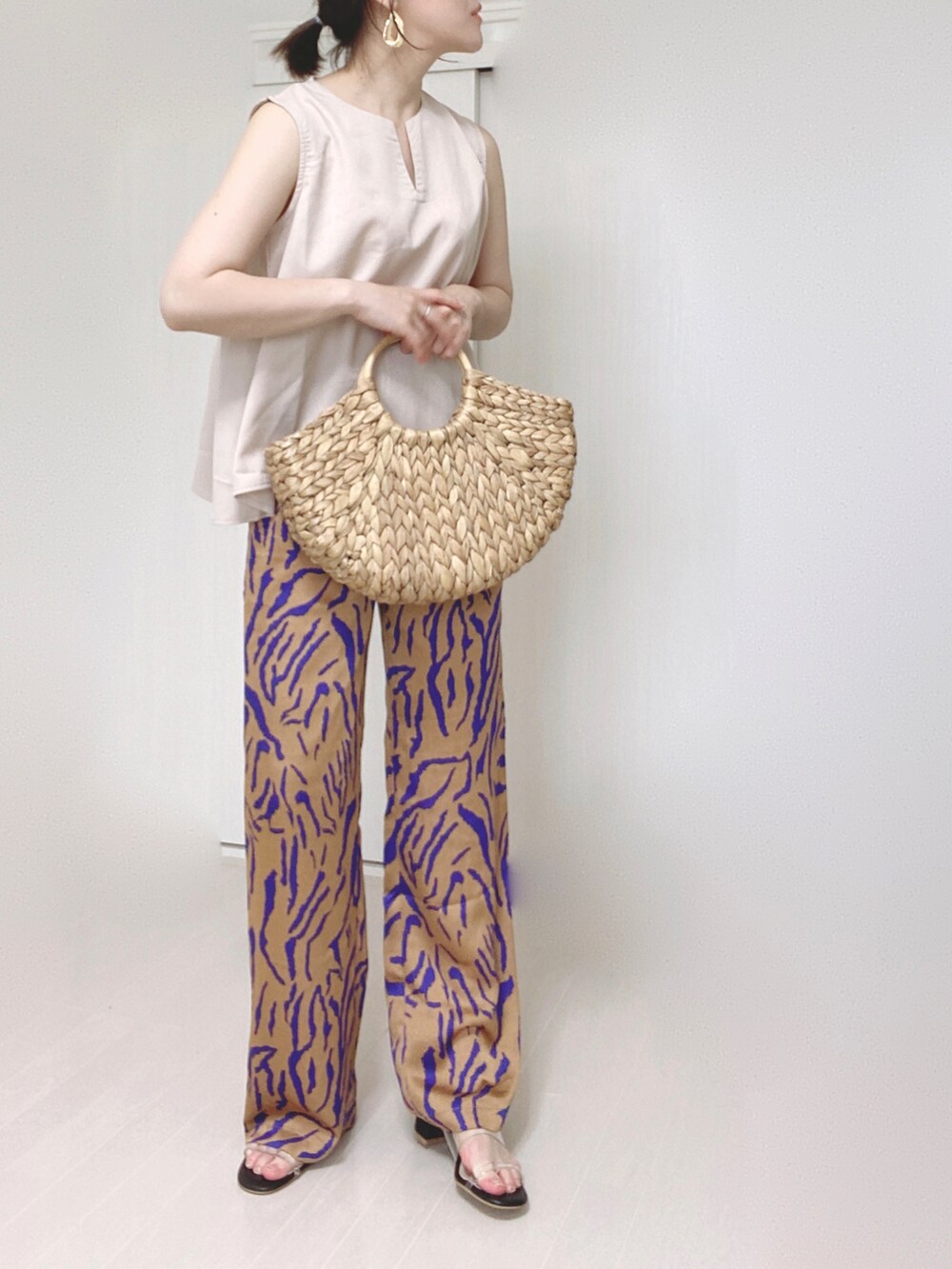 ホワイト系のシャツ/ブラウス、オレンジ系のその他パンツ、ベージュ系のかごバッグを着用したレディースの夏コーディネートの4枚目の写真