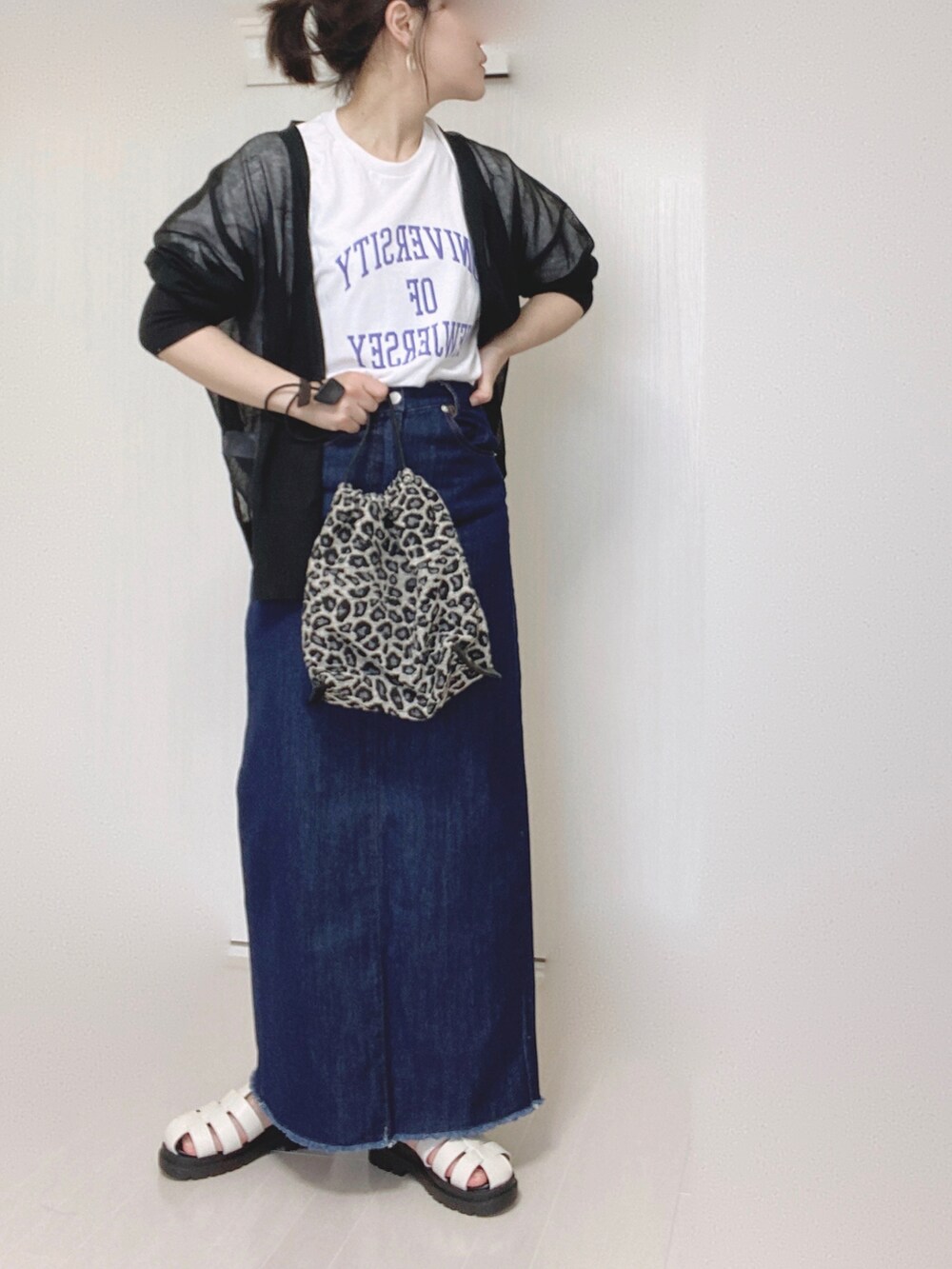 ブルー系のデニムスカート、ホワイト系のTシャツ/カットソー、ブラック系のカーディガン/ボレロを着用したレディースの夏コーディネートの4枚目の写真