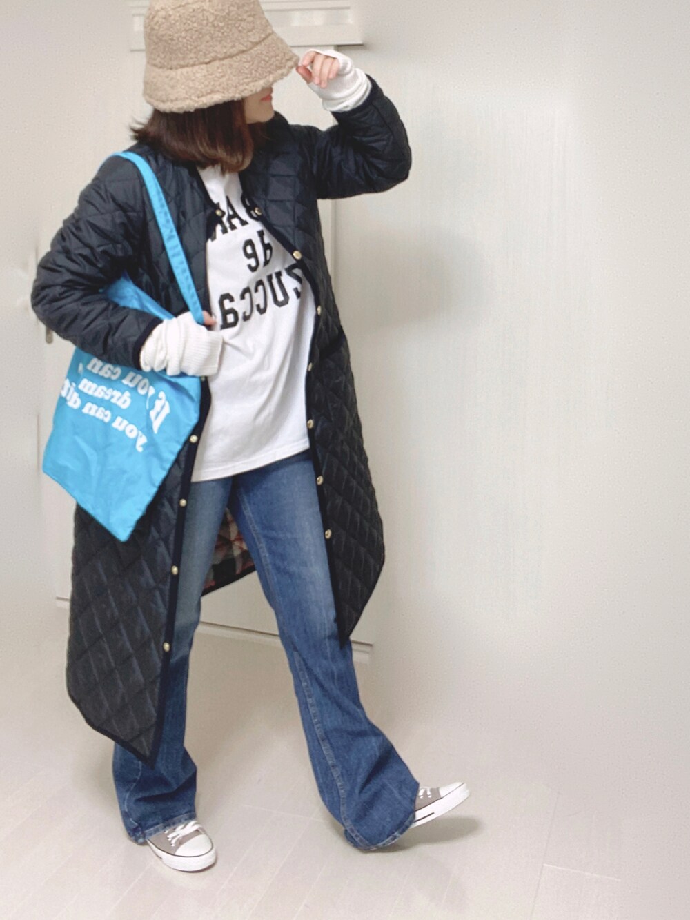 ブルー系のデニムパンツ、ブルー系のノーカラーコート、ホワイト系のTシャツ/カットソーを着用したレディースの秋コーディネートの2枚目の写真