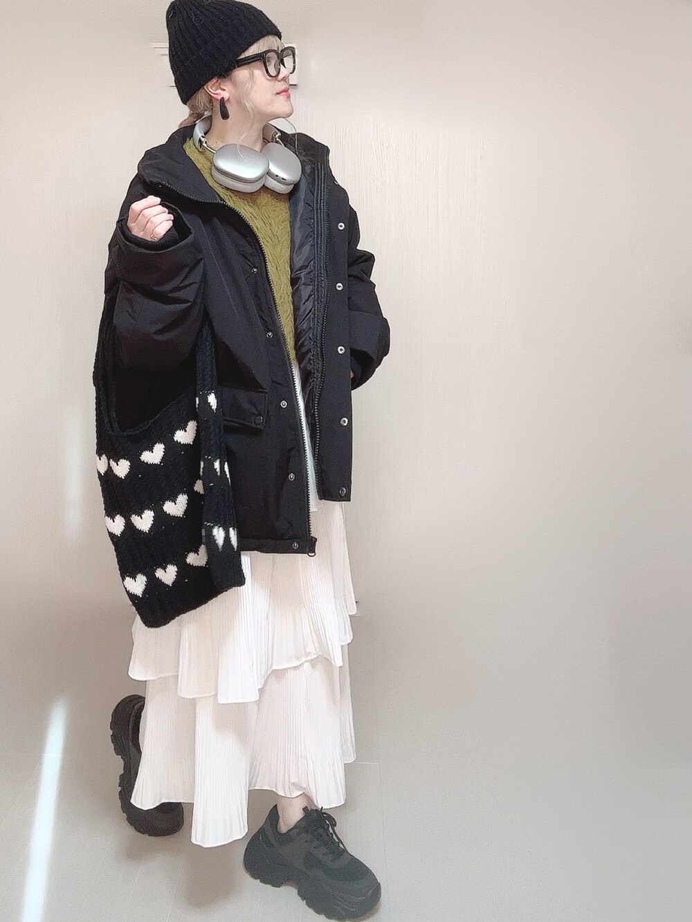 ブラック系のブルゾン、グリーン系のニット/セーター、ホワイト系のスカートを着用したレディースの冬コーディネートの3枚目の写真