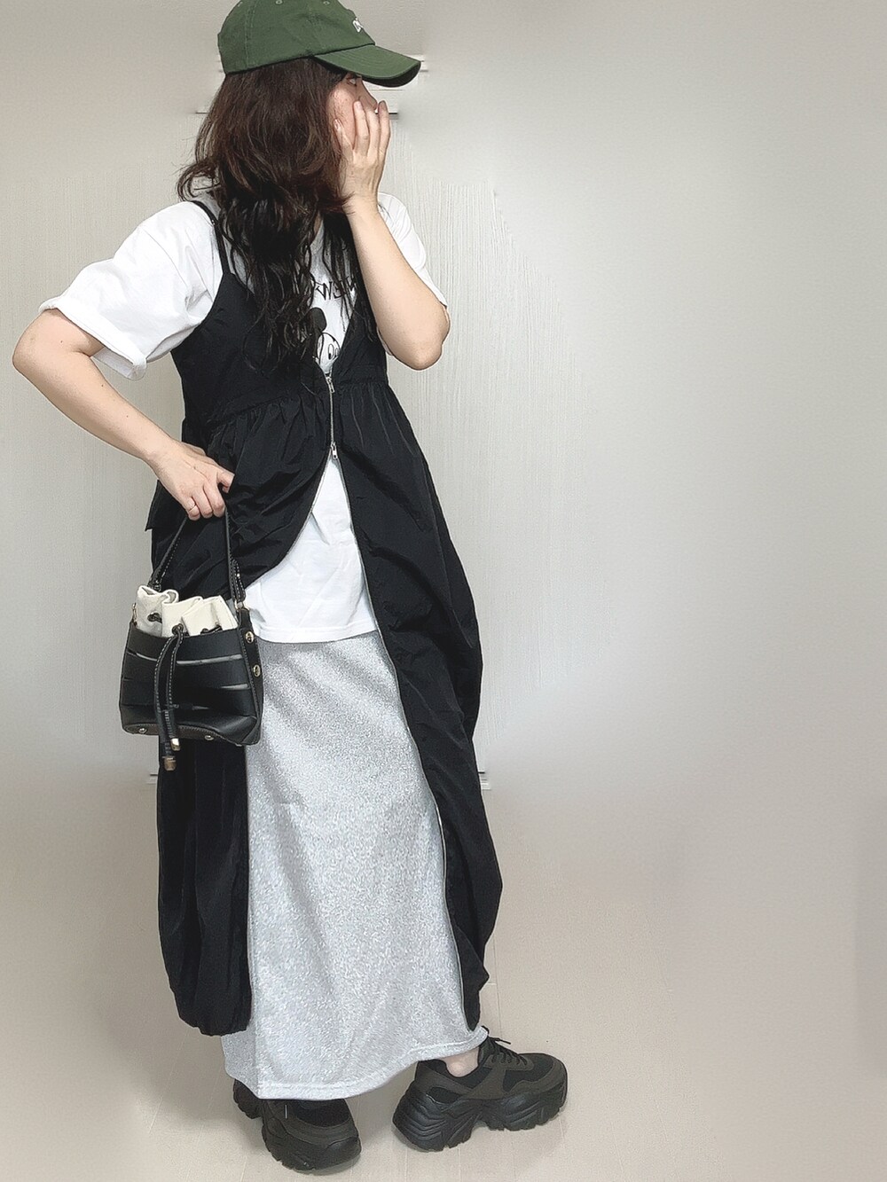 ブラック系のワンピース、ホワイト系のTシャツ/カットソー、ブラック系のショルダーバッグを着用したレディースの夏コーディネートの3枚目の写真