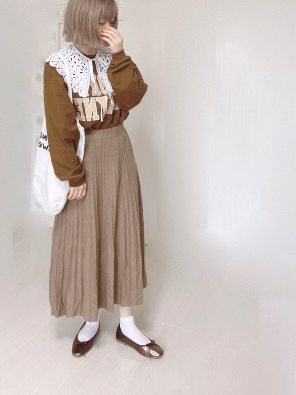 ブラウン系のバレエシューズ、ブラウン系のTシャツ/カットソー、ホワイト系のトートバッグを着用したレディースの秋コーディネートの2枚目の写真