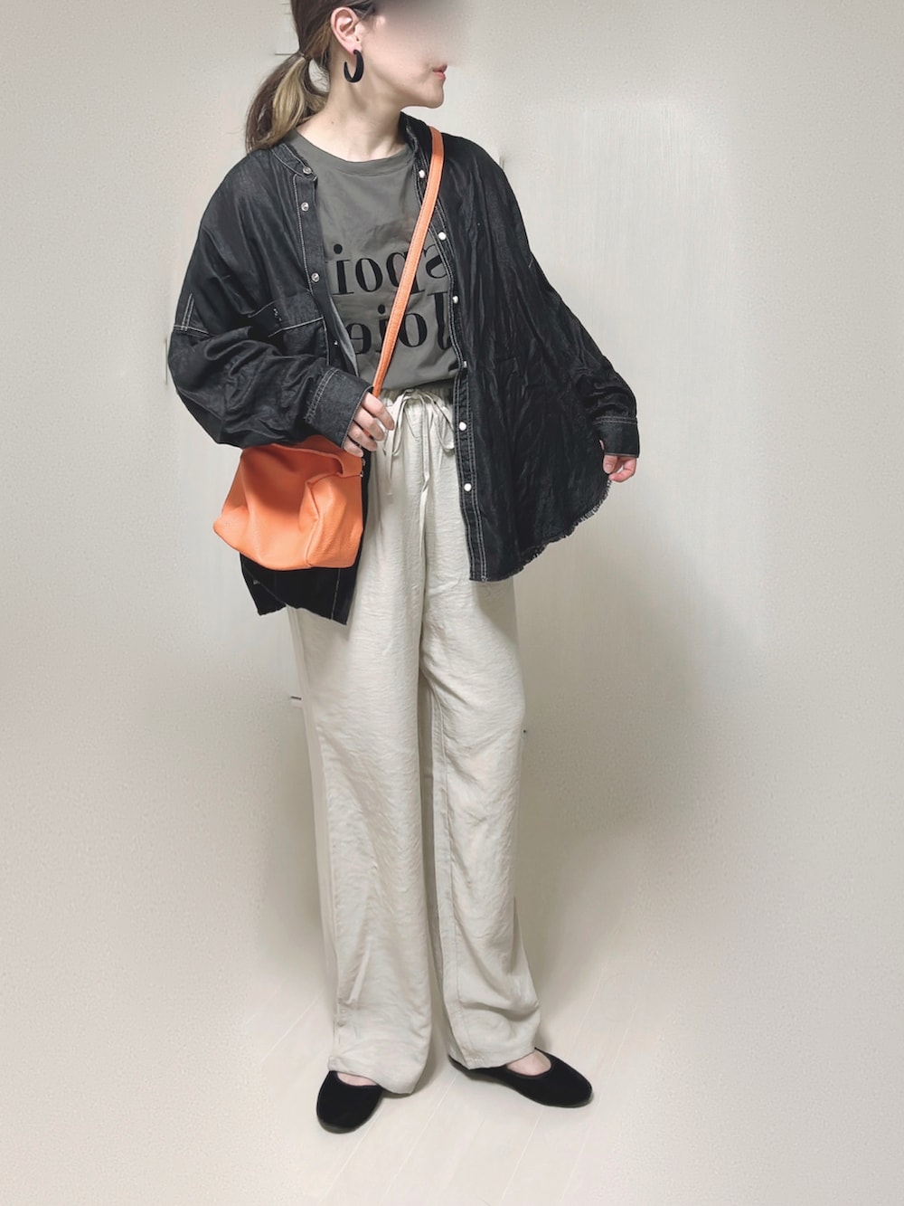 ブラック系のシャツ/ブラウス、オレンジ系のショルダーバッグ、ブラック系のパンプスを着用したレディースの秋コーディネートの4枚目の写真