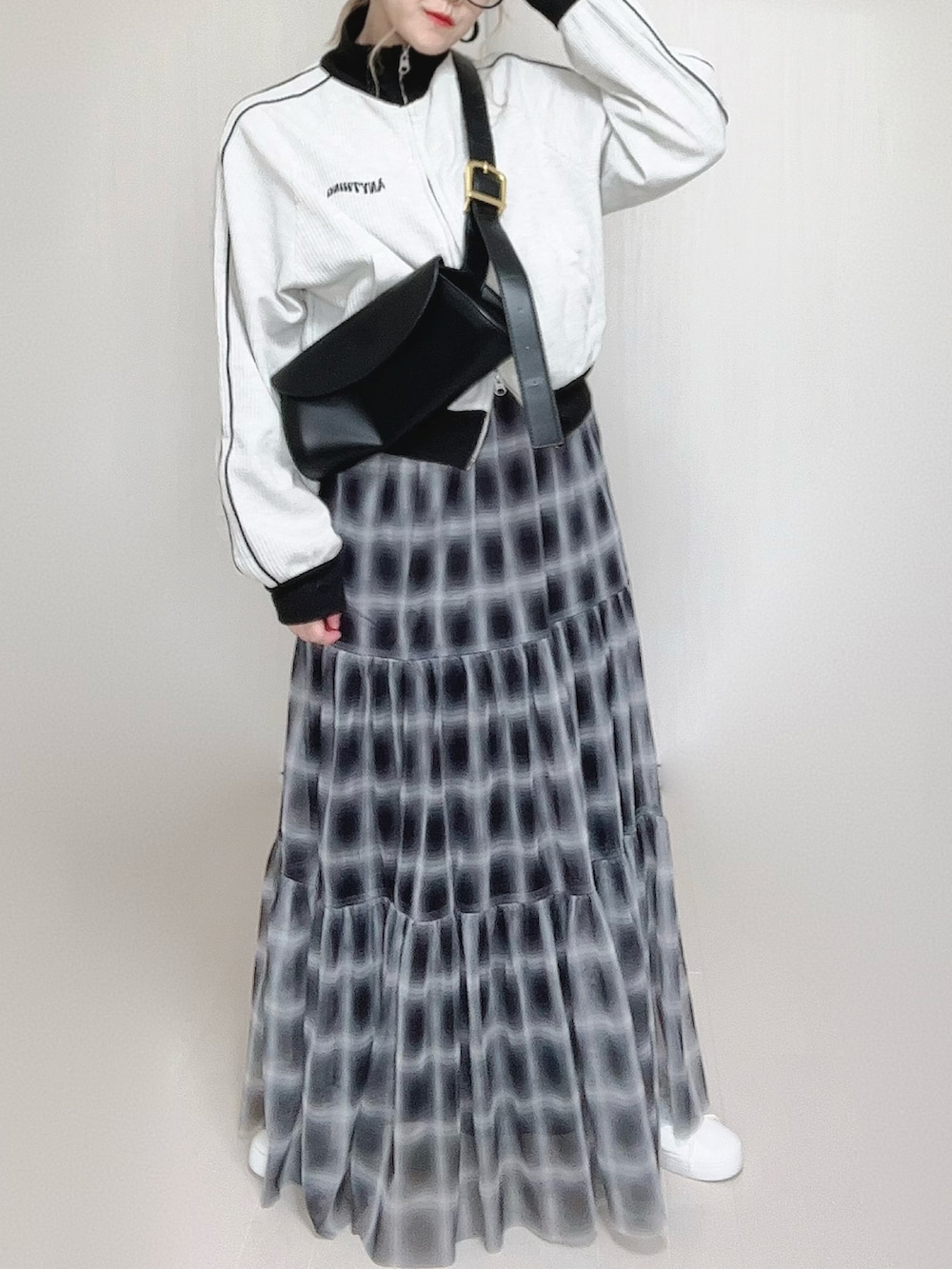 ブラック系のスカート、ベージュ系のジャージ、ホワイト系のスニーカーを着用したレディースの秋コーディネートの5枚目の写真