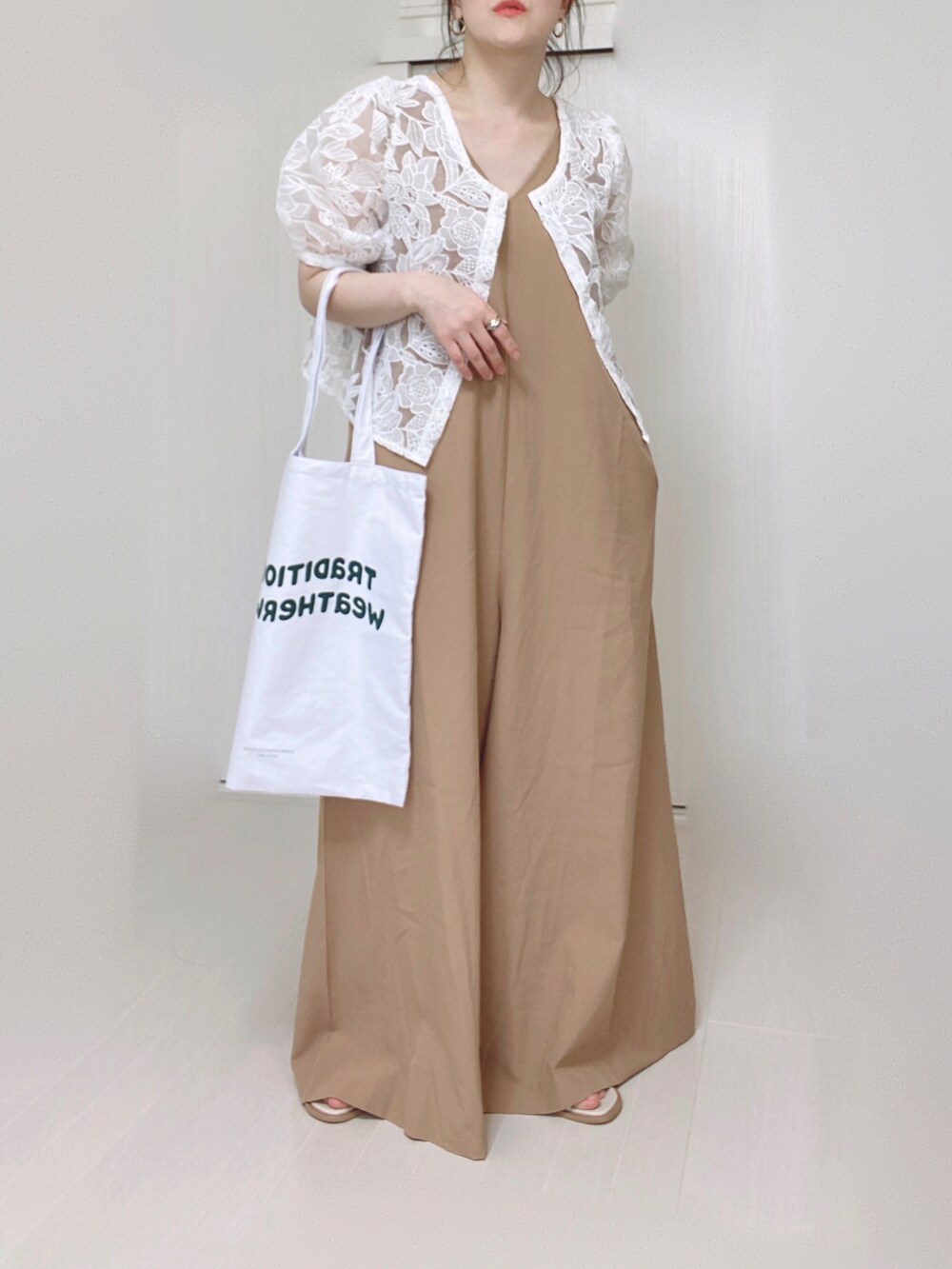 ベージュ系のサロペット/オーバーオール、ホワイト系のトートバッグ、ホワイト系のシャツ/ブラウスを着用したレディースの春コーディネートの2枚目の写真