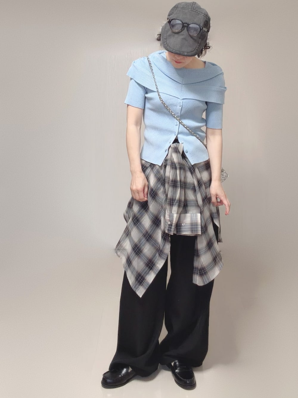 ブルー系のニット/セーター、ホワイト系のシャツ/ブラウス、ブラック系のスラックスを着用したレディースの春コーディネートの4枚目の写真