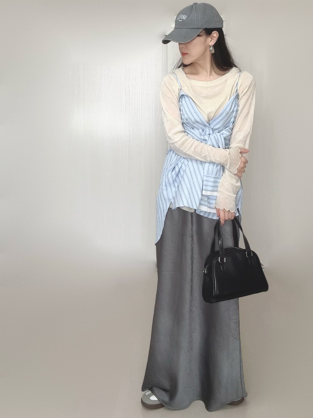 ブルー系のシャツ/ブラウス、グレー系のスカート、ブラック系のボストンバッグを着用したレディースの冬コーディネートの2枚目の写真