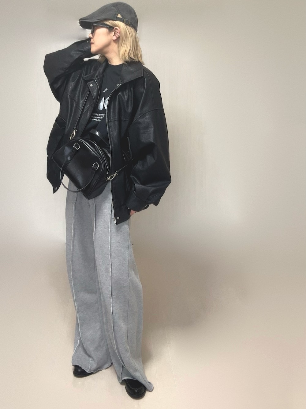 ブラック系のブルゾン、ブラック系のTシャツ/カットソー、グレー系のスウェットパンツを着用したレディースの冬コーディネートの2枚目の写真