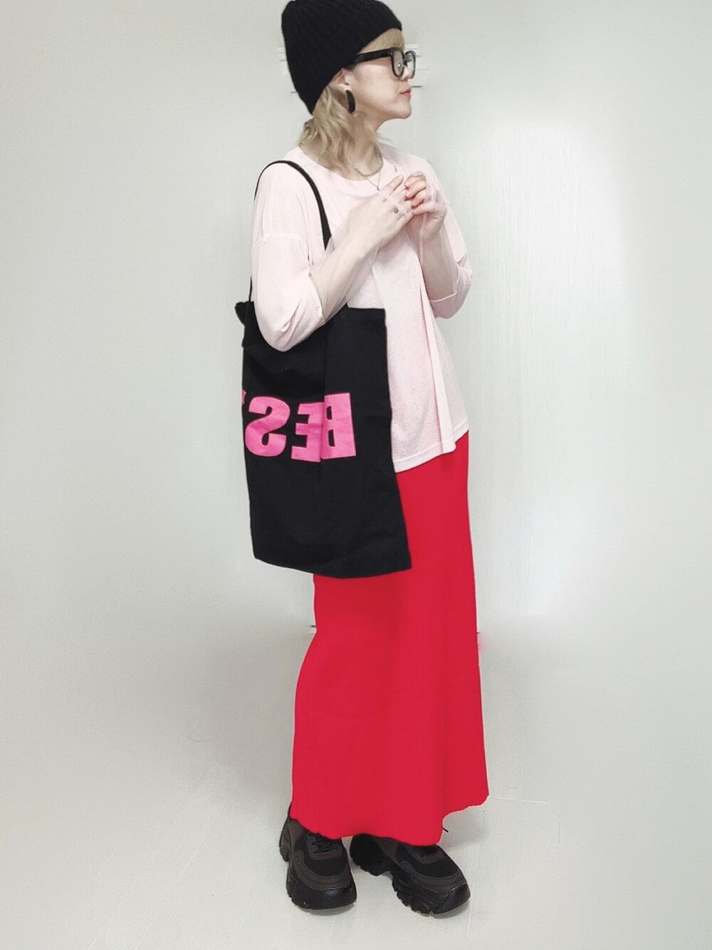 ピンク系のTシャツ/カットソー、ブラック系のトートバッグ、レッド系のスカートを着用したレディースの春コーディネートの4枚目の写真
