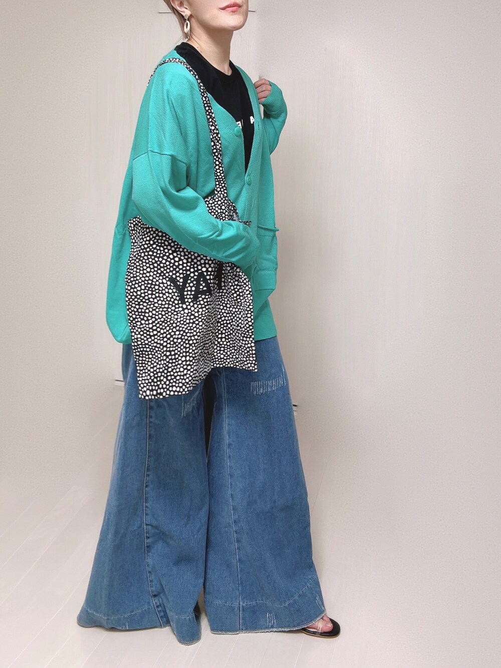 グリーン系のカーディガン/ボレロ、ブラック系のTシャツ/カットソー、ブラック系のサンダルを着用したレディースの春コーディネートの5枚目の写真