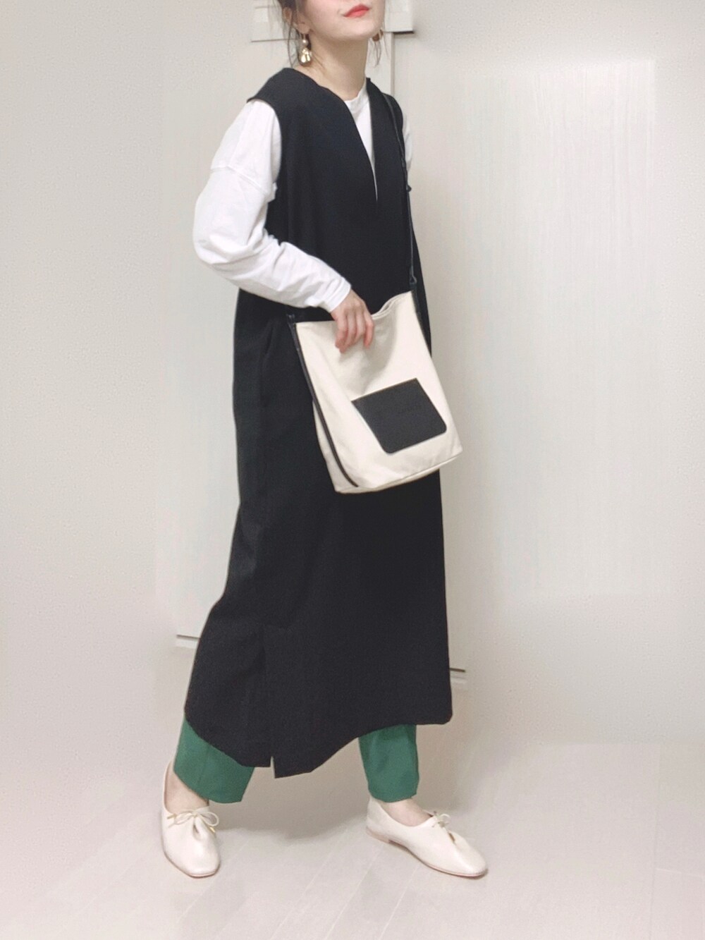 ホワイト系のショルダーバッグ、ブラック系のワンピース、ホワイト系のドレスシューズを着用したレディースの秋コーディネートの2枚目の写真