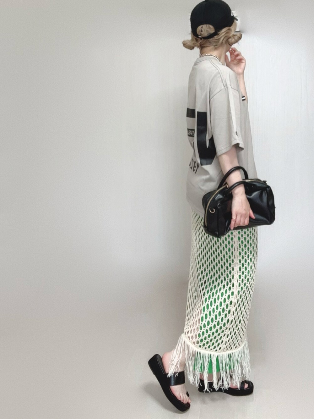 ホワイト系のスカート、ベージュ系のTシャツ/カットソー、ブラック系のサンダルを着用したレディースの夏コーディネートの3枚目の写真