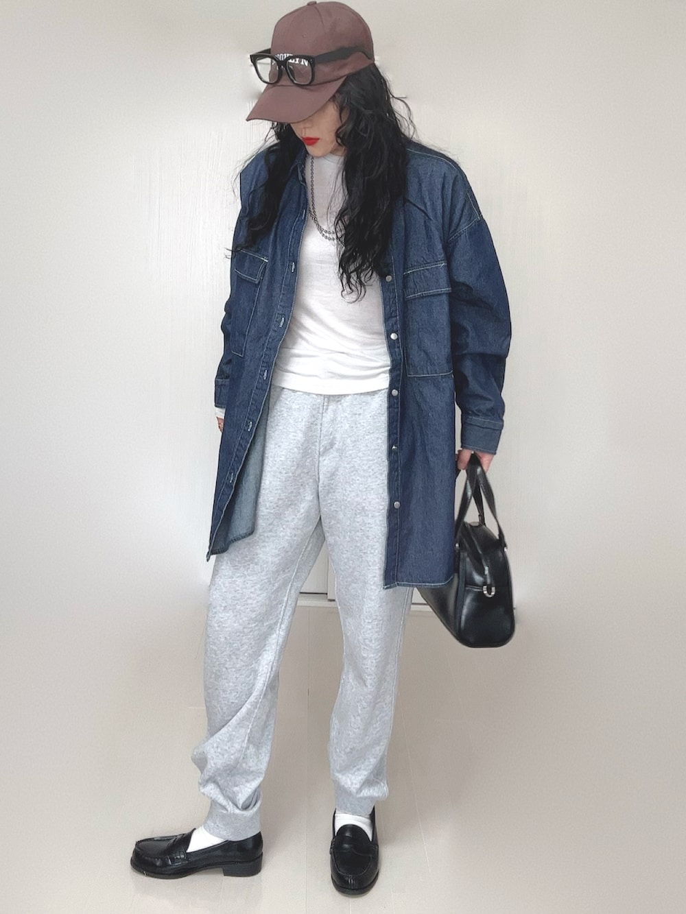 ブルー系のシャツ/ブラウス、ブラック系のボストンバッグ、ブラック系のローファーを着用したレディースの春コーディネートの4枚目の写真