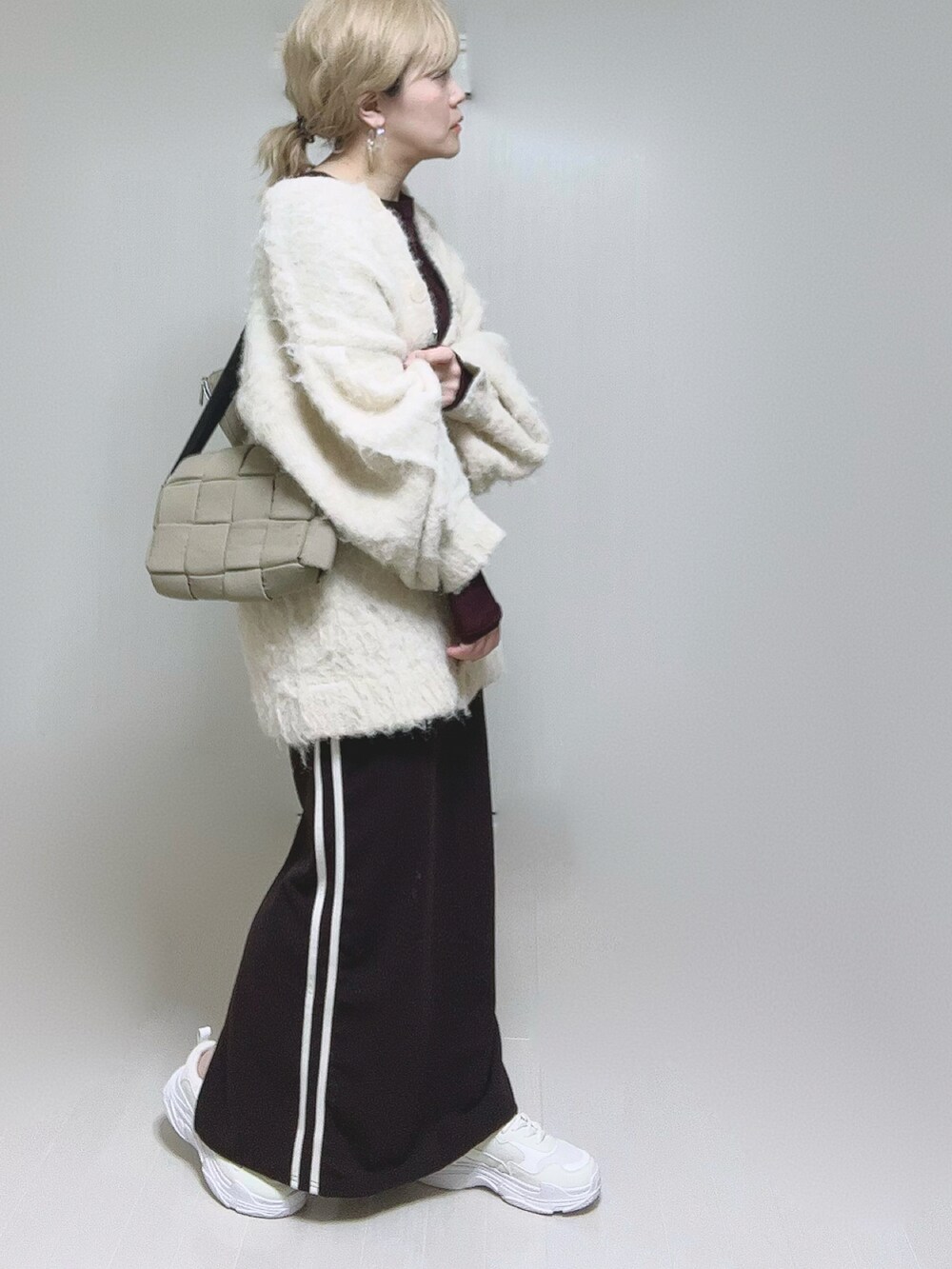 ベージュ系のカーディガン/ボレロ、ブラウン系のTシャツ/カットソー、ホワイト系のスニーカーを着用したレディースの冬コーディネートの2枚目の写真