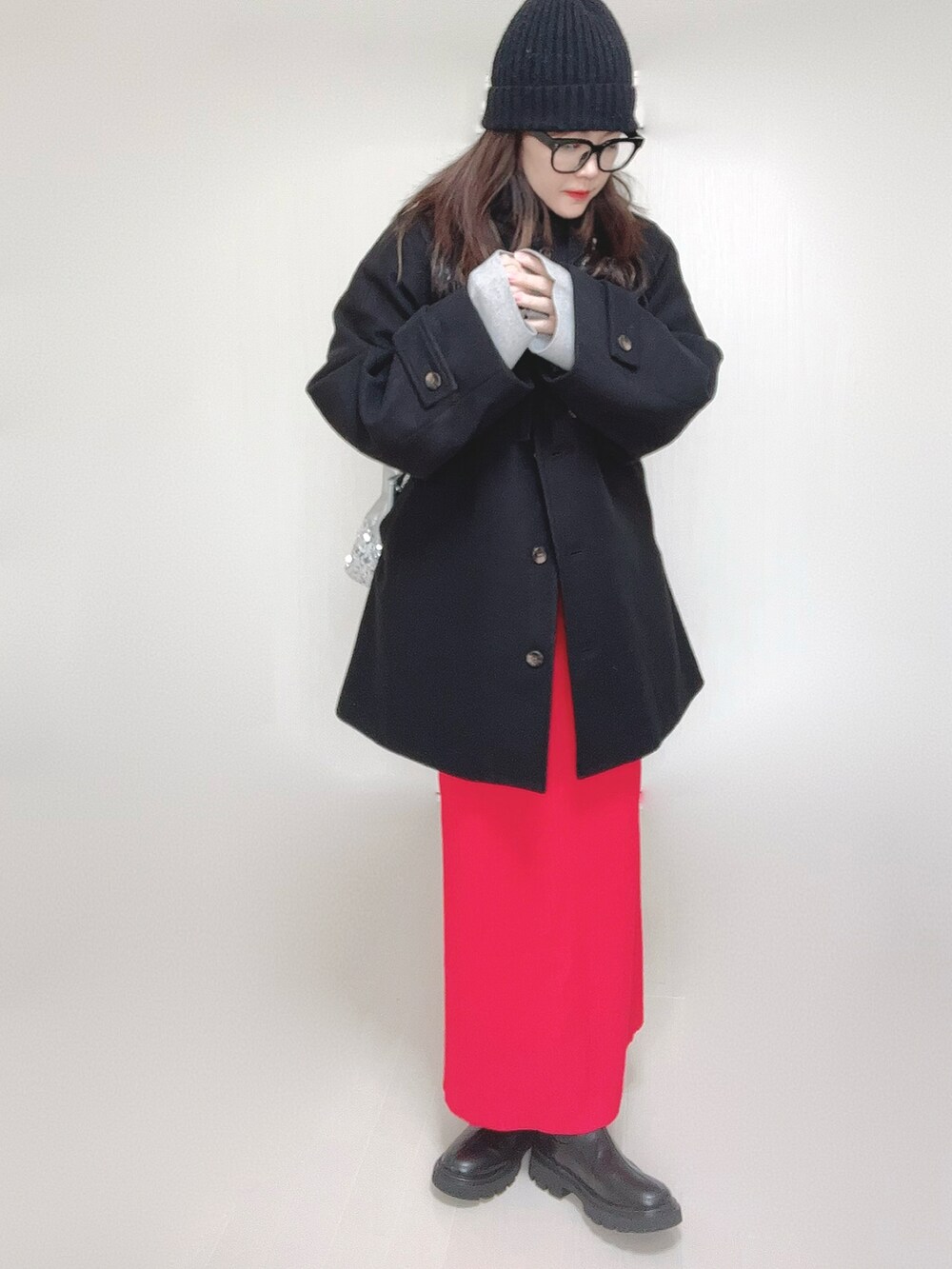 グレー系のトレンチコート、グレー系のワンピース、シルバー系のショルダーバッグを着用したレディースの秋コーディネートの4枚目の写真