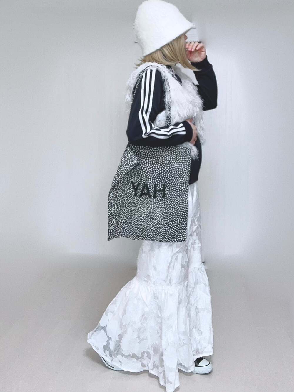 ホワイト系のベスト、ブルー系のナイロンジャケット、ホワイト系のスカートを着用したレディースの冬コーディネートの2枚目の写真