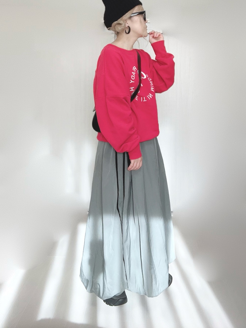 レッド系のスウェット、ブラック系のブーツを着用したレディースの冬コーディネートの5枚目の写真