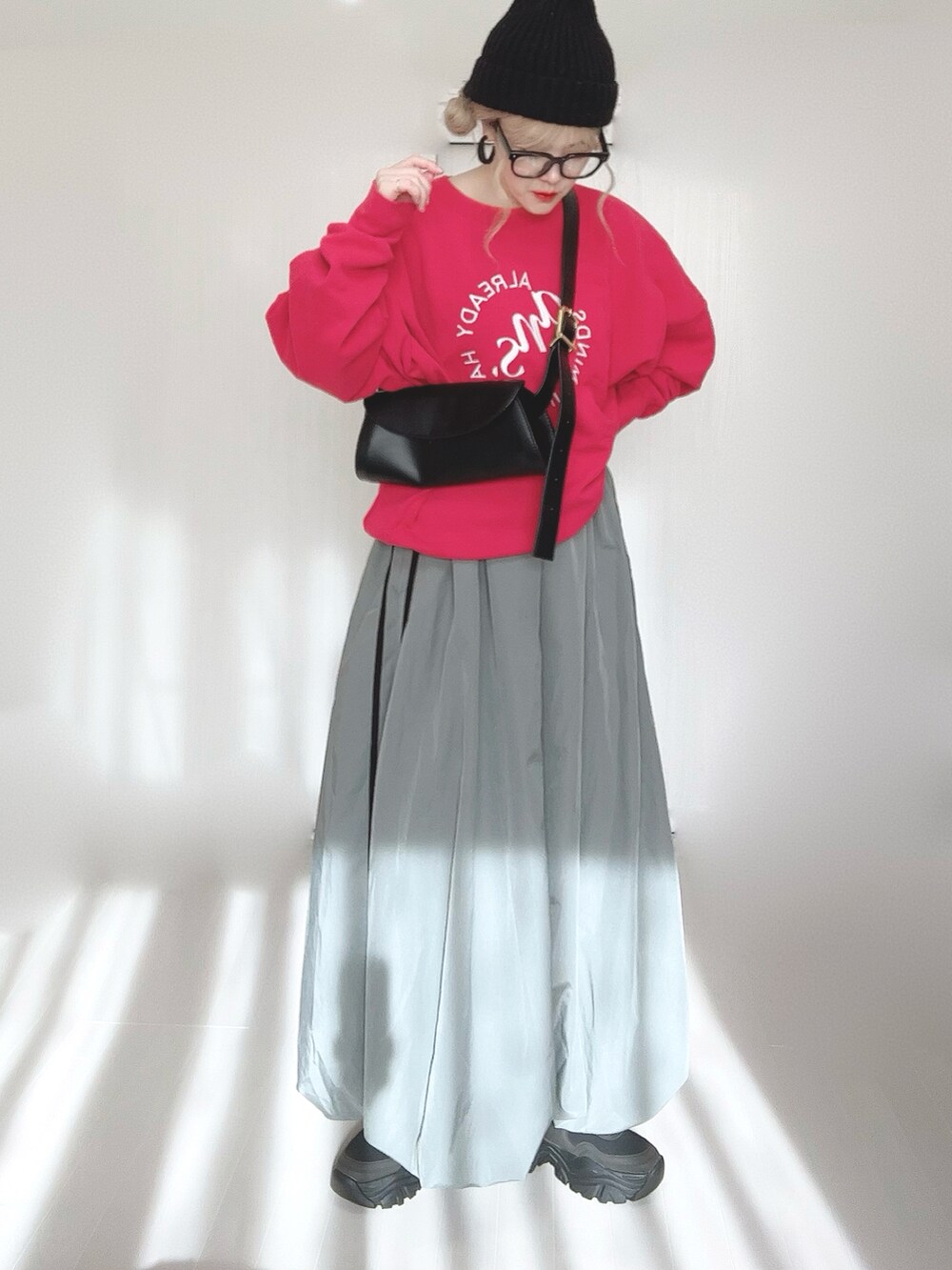 レッド系のスウェット、ブラック系のブーツを着用したレディースの冬コーディネートの2枚目の写真