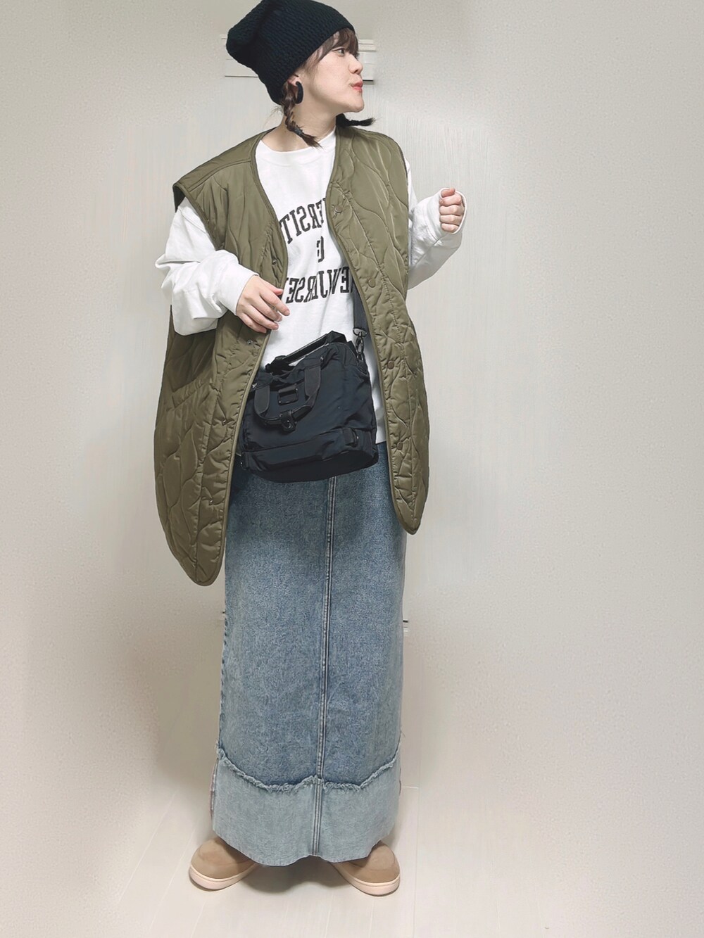 ベージュ系のMA-1、ホワイト系のスウェット、ブラック系のショルダーバッグを着用したレディースの冬コーディネートの3枚目の写真