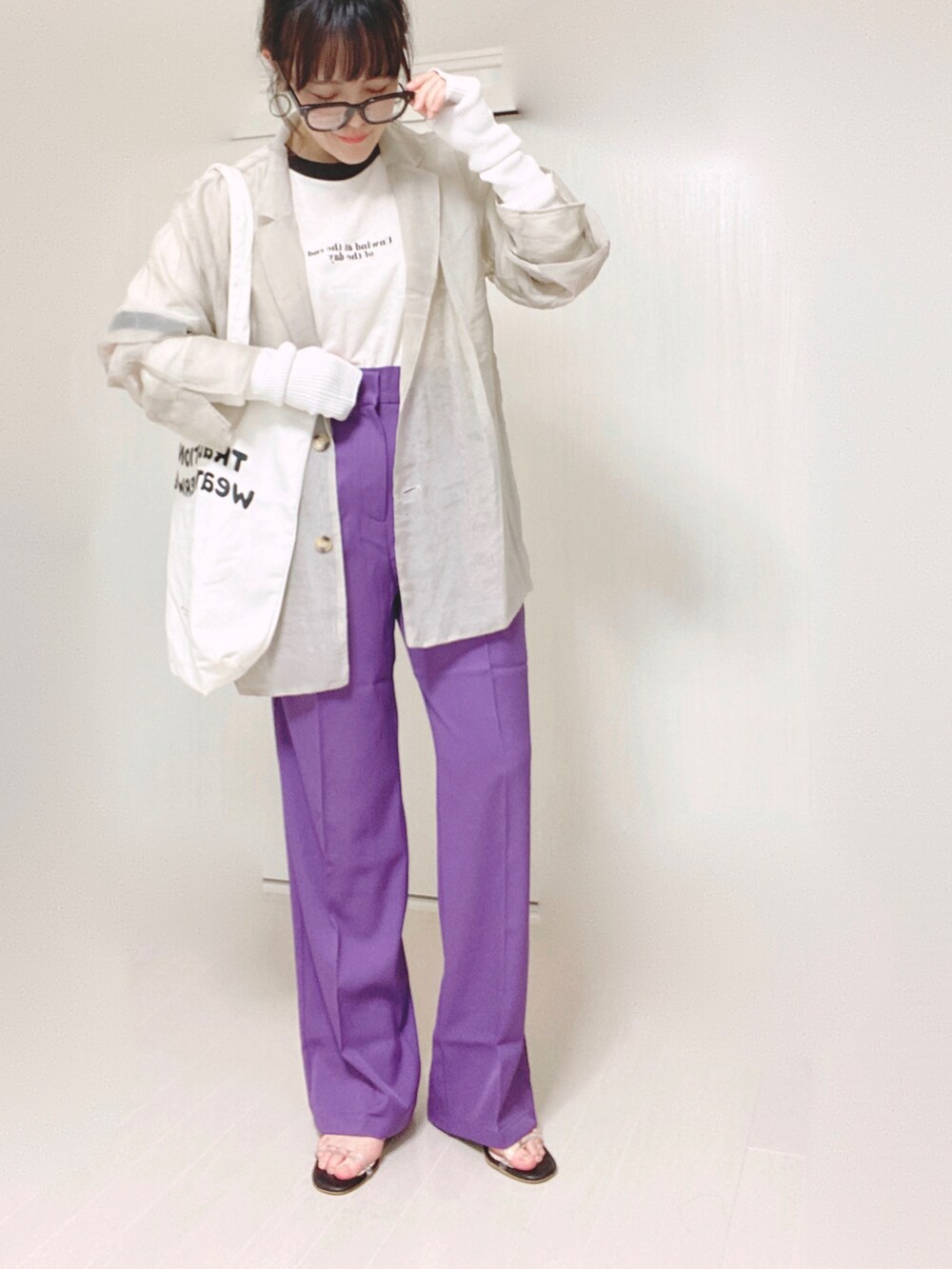 パープル系のスラックス、グレー系のテーラードジャケット、ホワイト系のトートバッグを着用したレディースの秋コーディネートの5枚目の写真