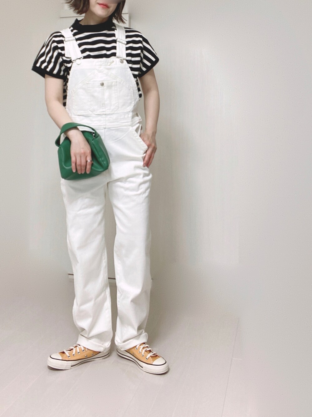 ホワイト系のTシャツ/カットソー、ホワイト系のサロペット/オーバーオール、グリーン系のハンドバッグを着用したレディースの春コーディネートの3枚目の写真