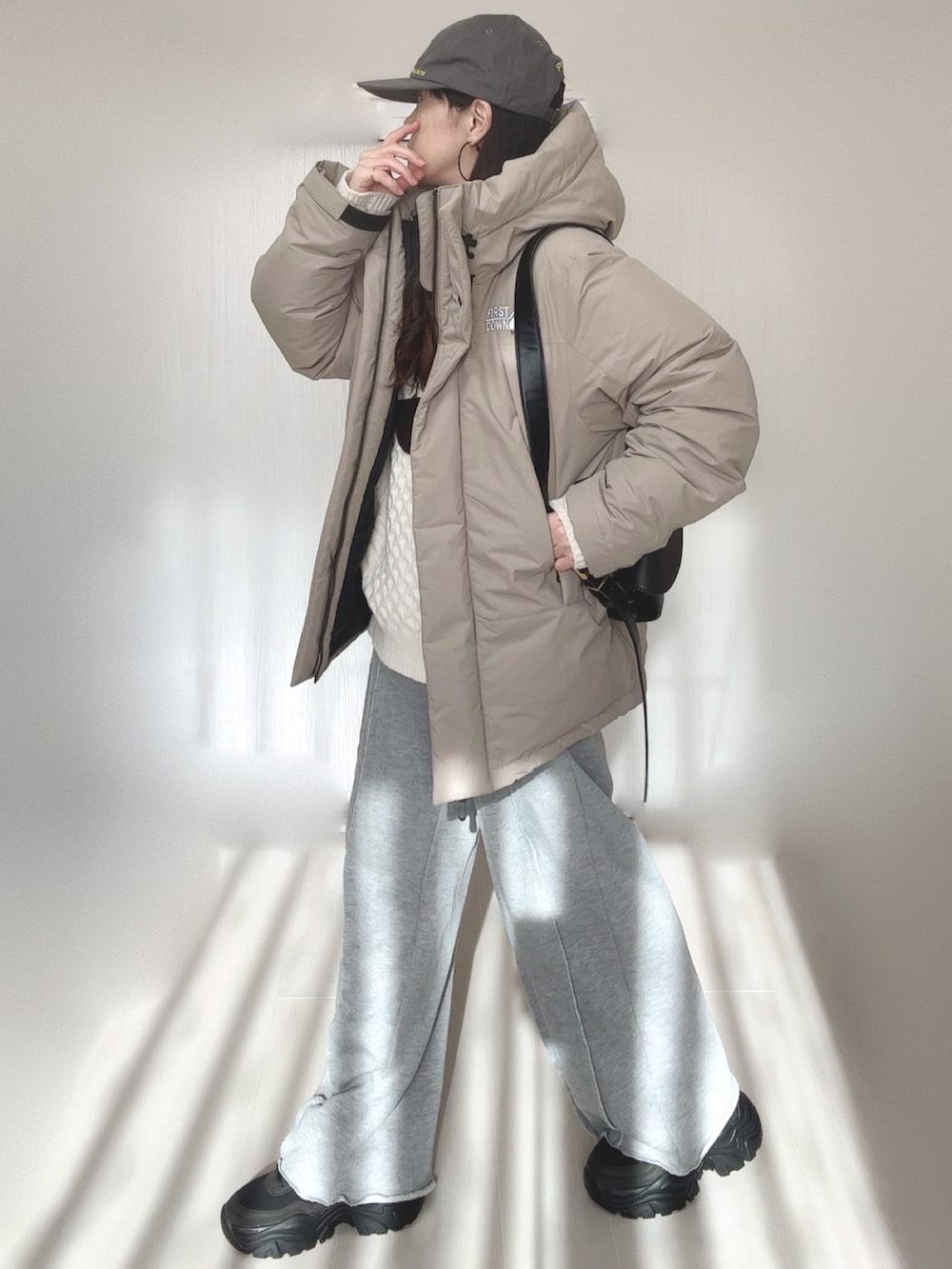 ベージュ系のダウンジャケット/コート、グレー系のスウェットパンツ、ホワイト系のニット/セーターを着用したレディースの冬コーディネートの4枚目の写真