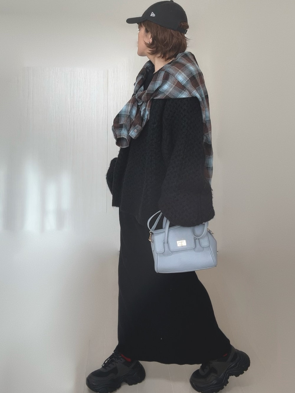 ブラウン系のシャツ/ブラウス、ブラック系のニット/セーター、ブラック系のスカートを着用したレディースの冬コーディネートの3枚目の写真