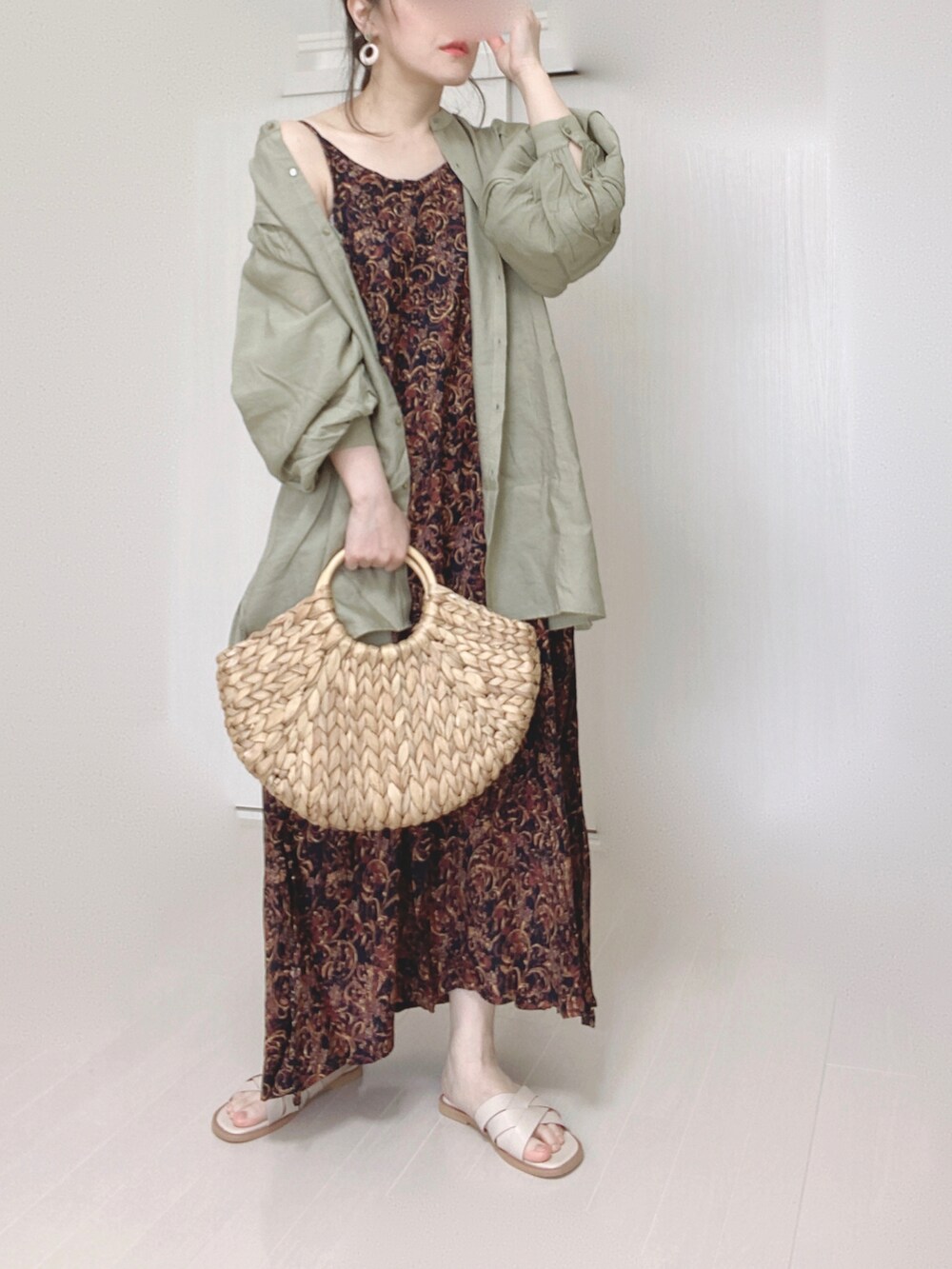 ブラック系のワンピース、グリーン系のシャツ/ブラウス、ホワイト系のサンダルを着用したレディースの春コーディネートの2枚目の写真