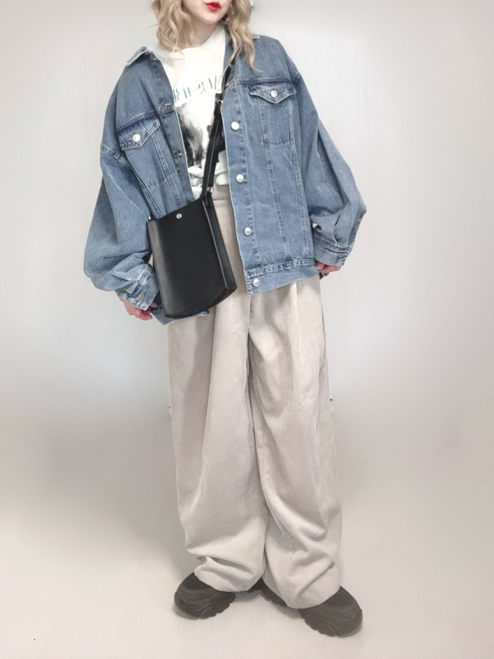 ブルー系のデニムジャケット、ホワイト系のTシャツ/カットソー、ブラック系のショルダーバッグを着用したレディースの春コーディネートの4枚目の写真