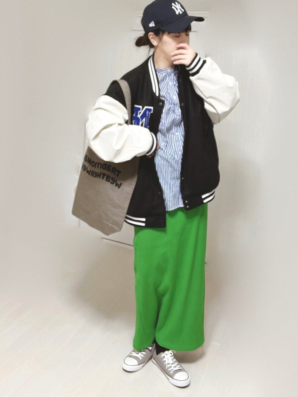 ブルー系のシャツ/ブラウス、ブラック系のスタジャン、ブラウン系のトートバッグを着用したレディースの春コーディネートの3枚目の写真