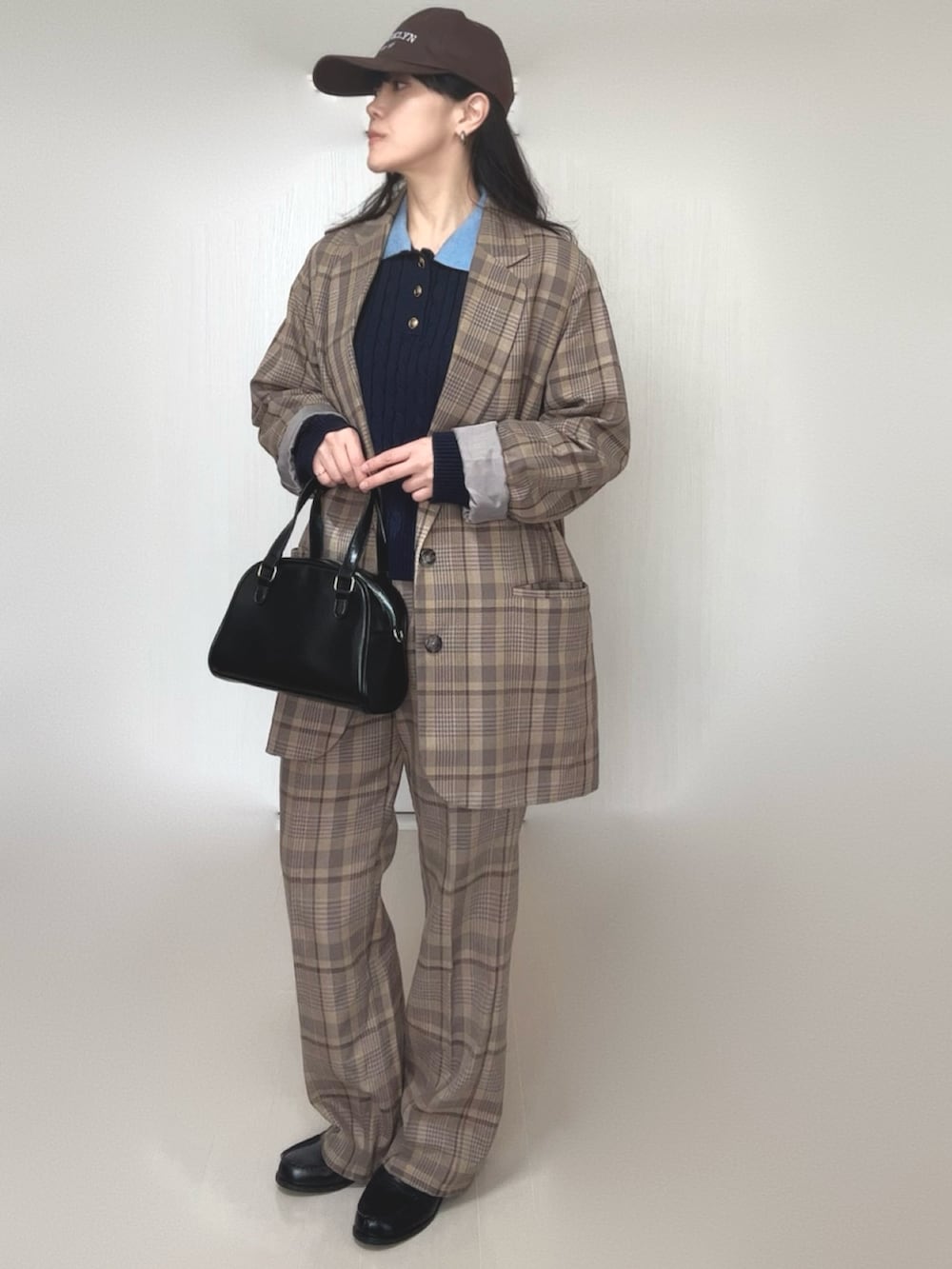 ブルー系のニット/セーター、ブラック系のボストンバッグ、ブラック系のローファーを着用したレディースの冬コーディネートの2枚目の写真