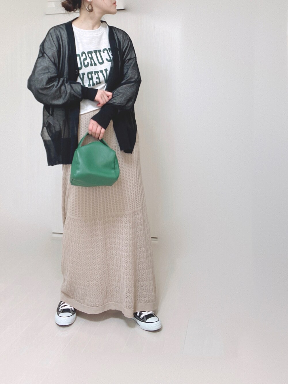 ブラック系のカーディガン/ボレロ、グリーン系のハンドバッグ、ブラック系のスニーカーを着用したレディースの春コーディネートの4枚目の写真