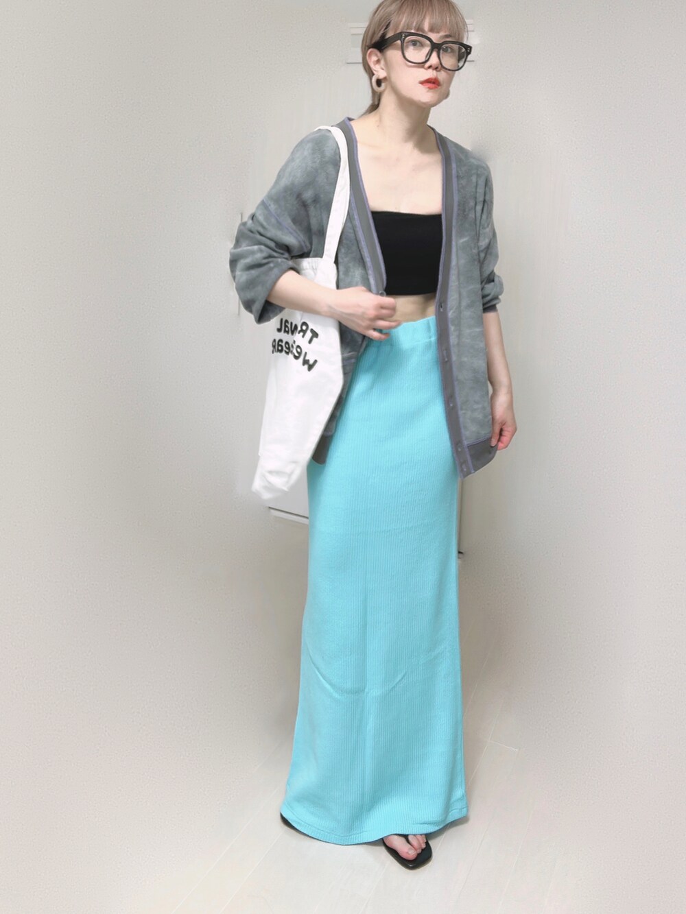 ブラック系のカーディガン/ボレロ、ホワイト系のトートバッグ、ブルー系のスカートを着用したレディースの春コーディネートの2枚目の写真