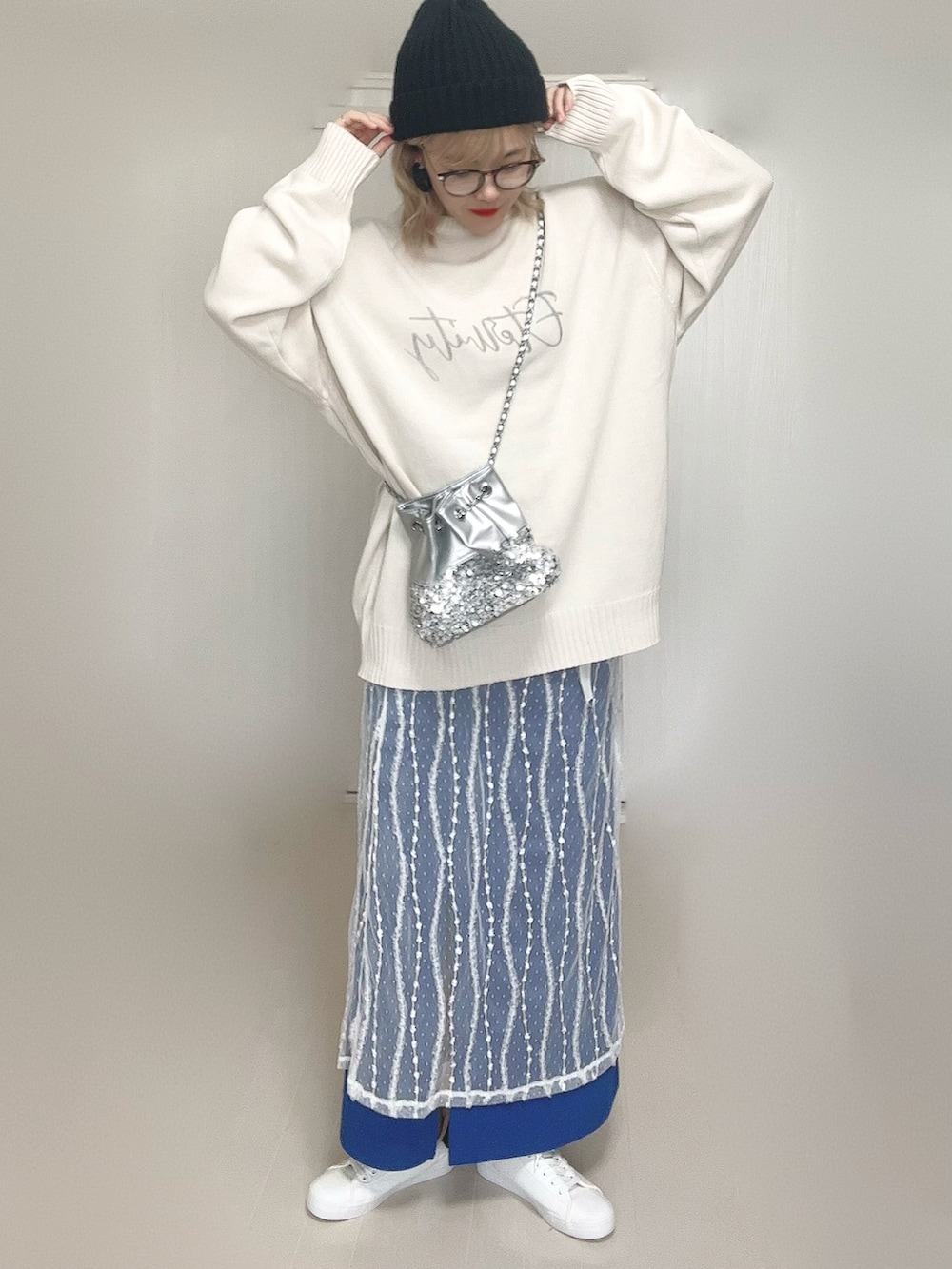ホワイト系のニット/セーター、シルバー系のショルダーバッグ、ホワイト系のスカートを着用したレディースの秋コーディネートの3枚目の写真