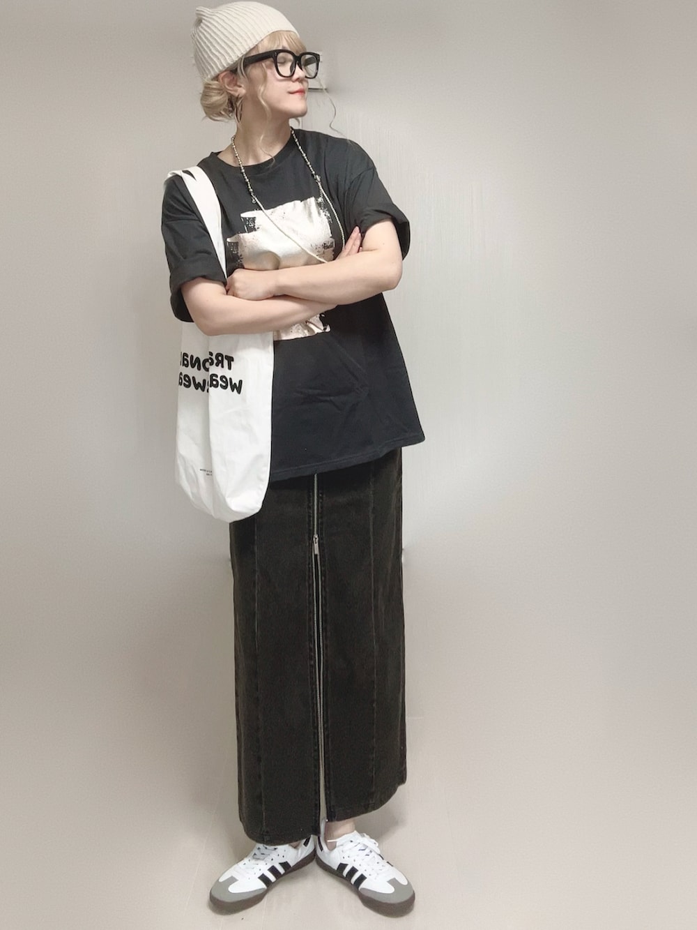 ブラック系のTシャツ/カットソー、ブラック系のスカート、ホワイト系のトートバッグを着用したレディースの夏コーディネートの3枚目の写真