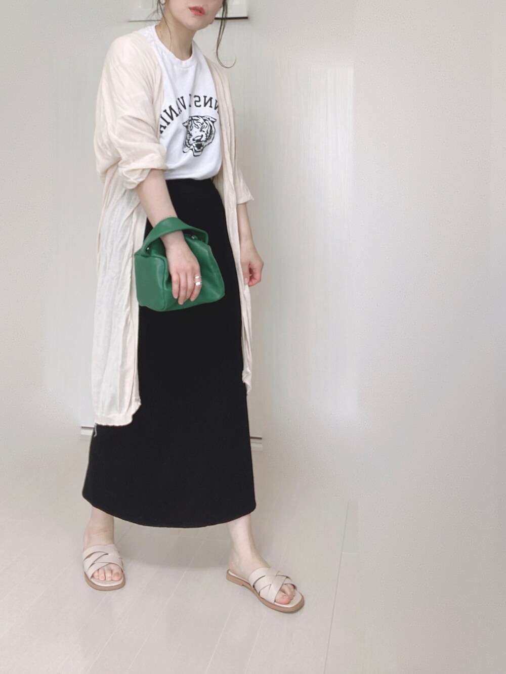 ホワイト系のサンダル、ホワイト系のTシャツ/カットソー、ベージュ系のカーディガン/ボレロを着用したレディースの春コーディネートの2枚目の写真