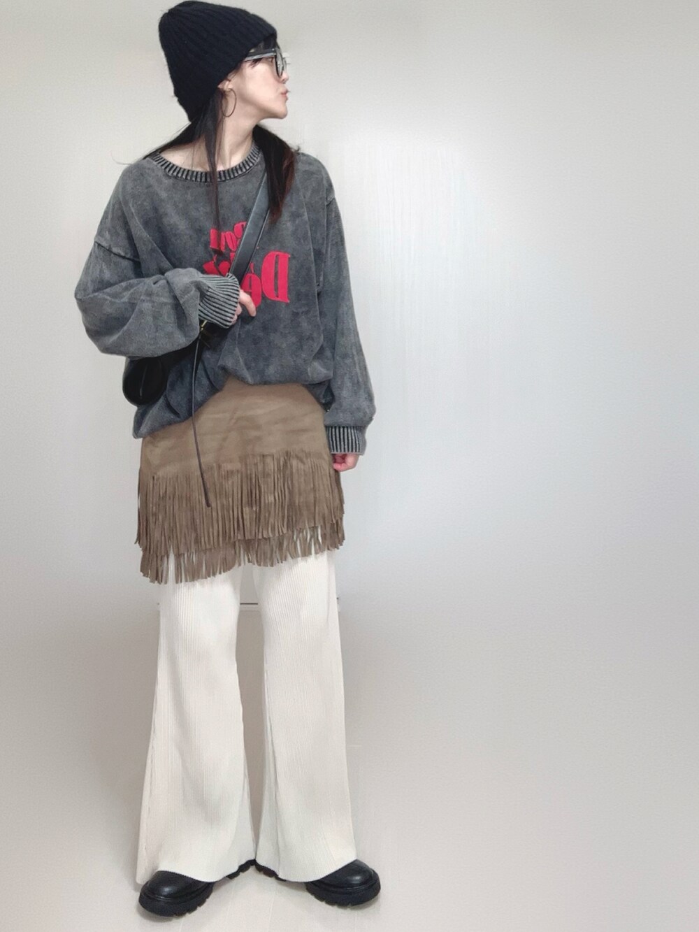 ブラック系のニット/セーター、ホワイト系のその他パンツ、ブラック系のブーツを着用したレディースの秋コーディネートの2枚目の写真