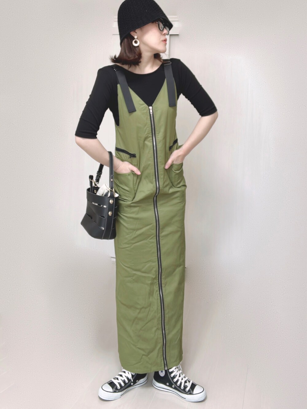 グリーン系のジャンパースカート、ブラック系のTシャツ/カットソー、ブラック系のショルダーバッグを着用したレディースの夏コーディネートの4枚目の写真