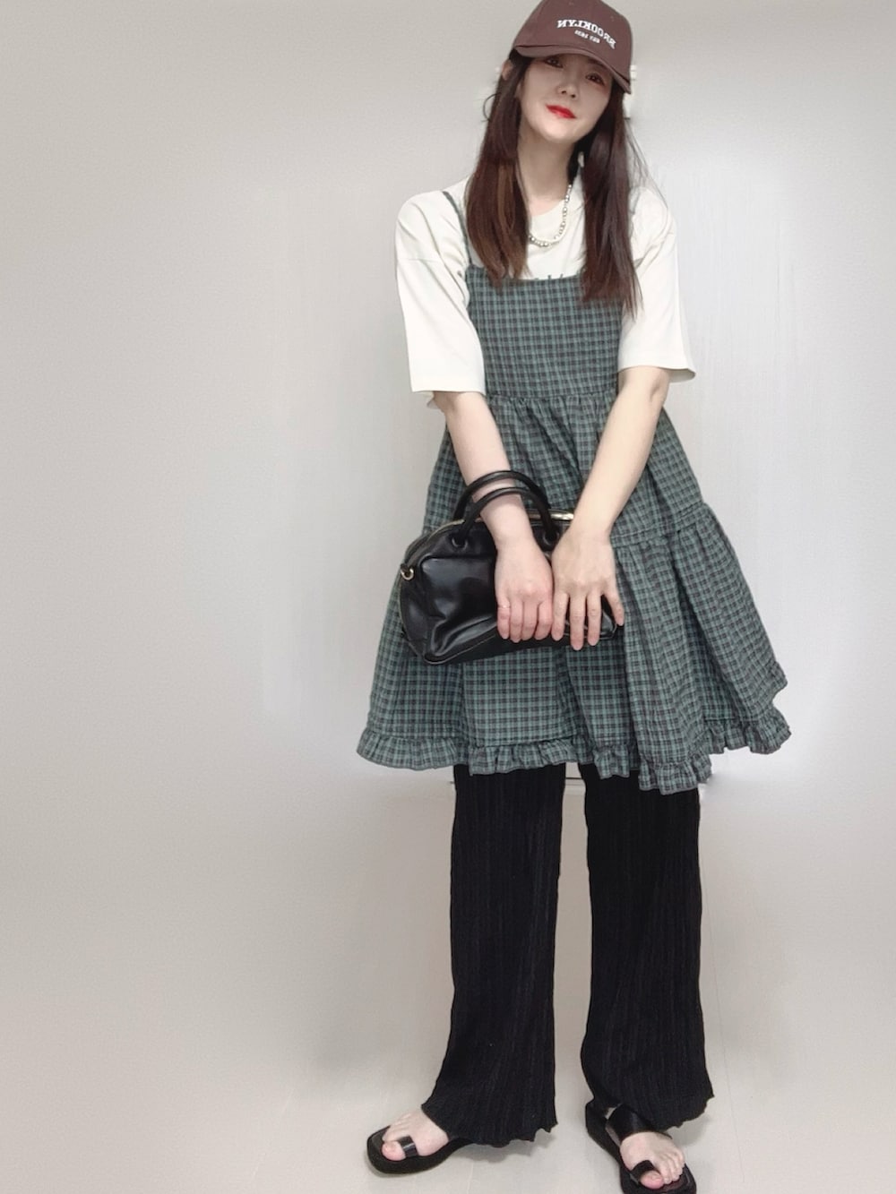 グレー系のワンピース、ホワイト系のTシャツ/カットソー、ブラック系のボストンバッグを着用したレディースの夏コーディネートの5枚目の写真