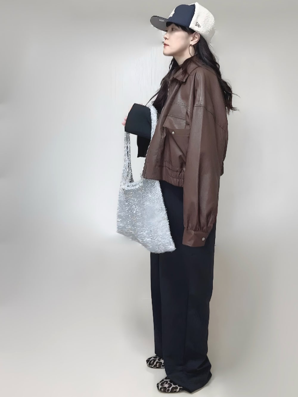 ブラック系のカーディガン/ボレロ、ブラウン系のブルゾン、ブラック系のつなぎ/オールインワンを着用したレディースの冬コーディネートの2枚目の写真