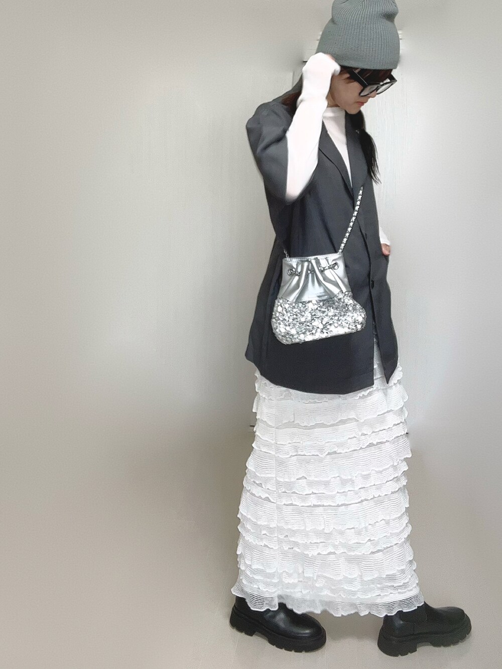 グレー系のテーラードジャケット、ブラック系のブーツ、ホワイト系のTシャツ/カットソーを着用したレディースの秋コーディネートの3枚目の写真