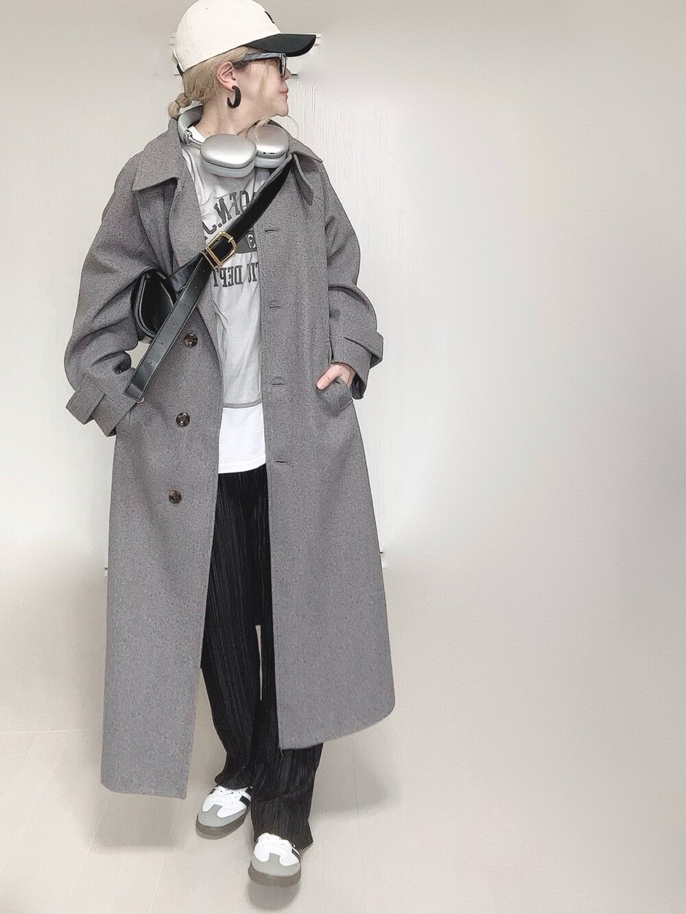グレー系のステンカラーコート、ホワイト系のTシャツ/カットソー、ブラック系のその他パンツを着用したレディースの冬コーディネートの3枚目の写真